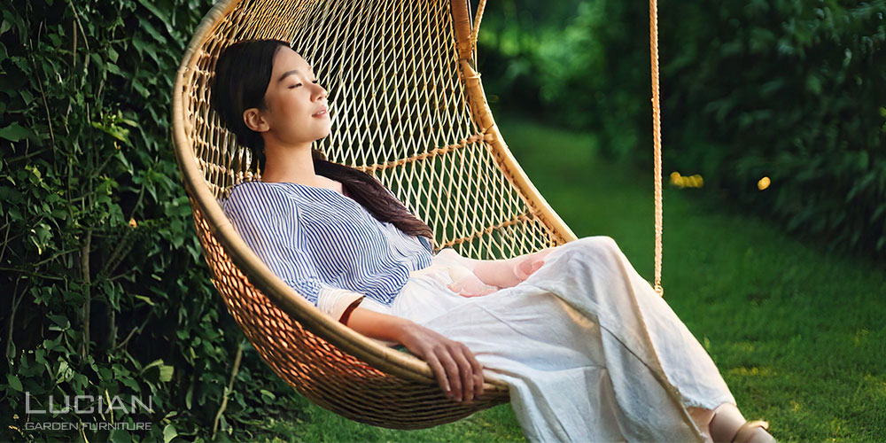 ハンギングチェアでくつろぐ女性